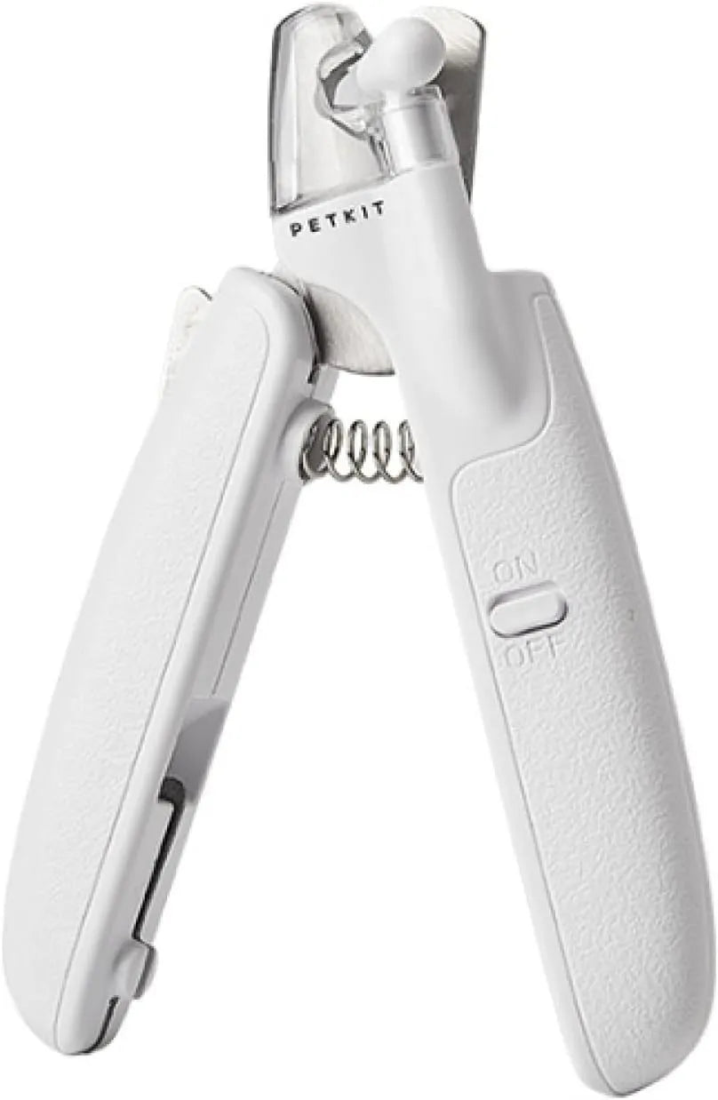 White pet nail clippers with LED light and transparent anti-splash guard next to a nail file on a table