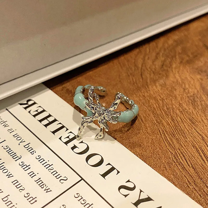 Creative butterfly design women's ring in copper with oil drip finish, showing an open loop style.
