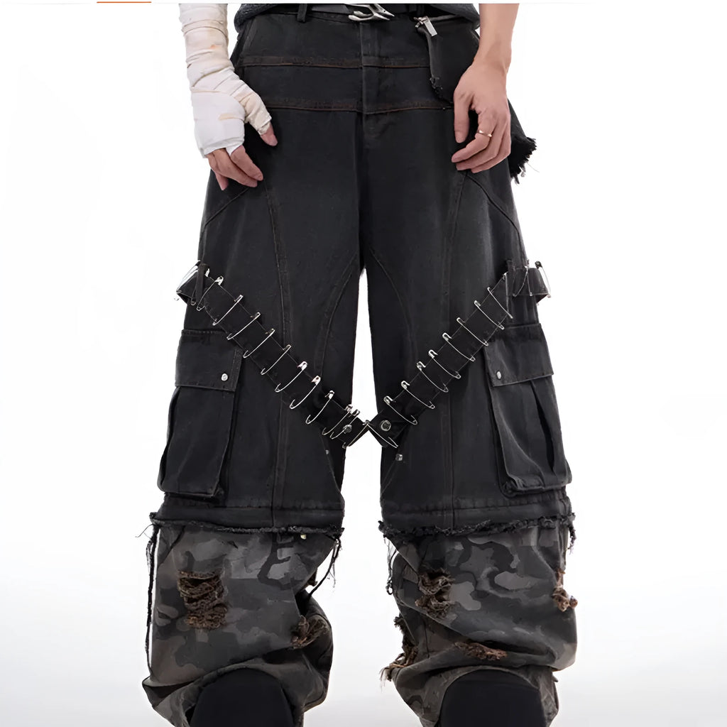 Men's grey jeans with camouflage splicing design and pin and ribbon details on the legs.
