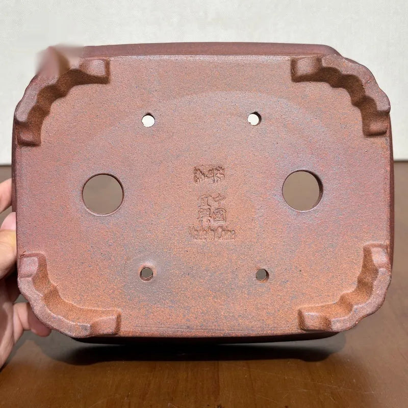 Reddish brown hand-glazed stoneware rectangular bonsai flower pot on a flat surface