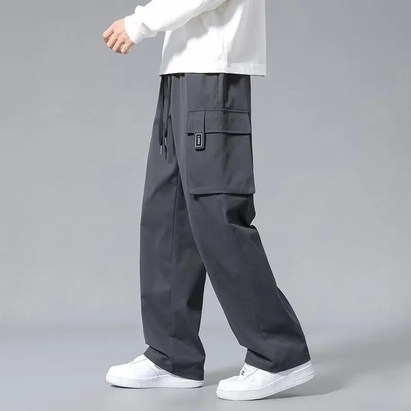 Boys' straight-leg cargo trousers in army green with large pockets and a drawstring waistband.
