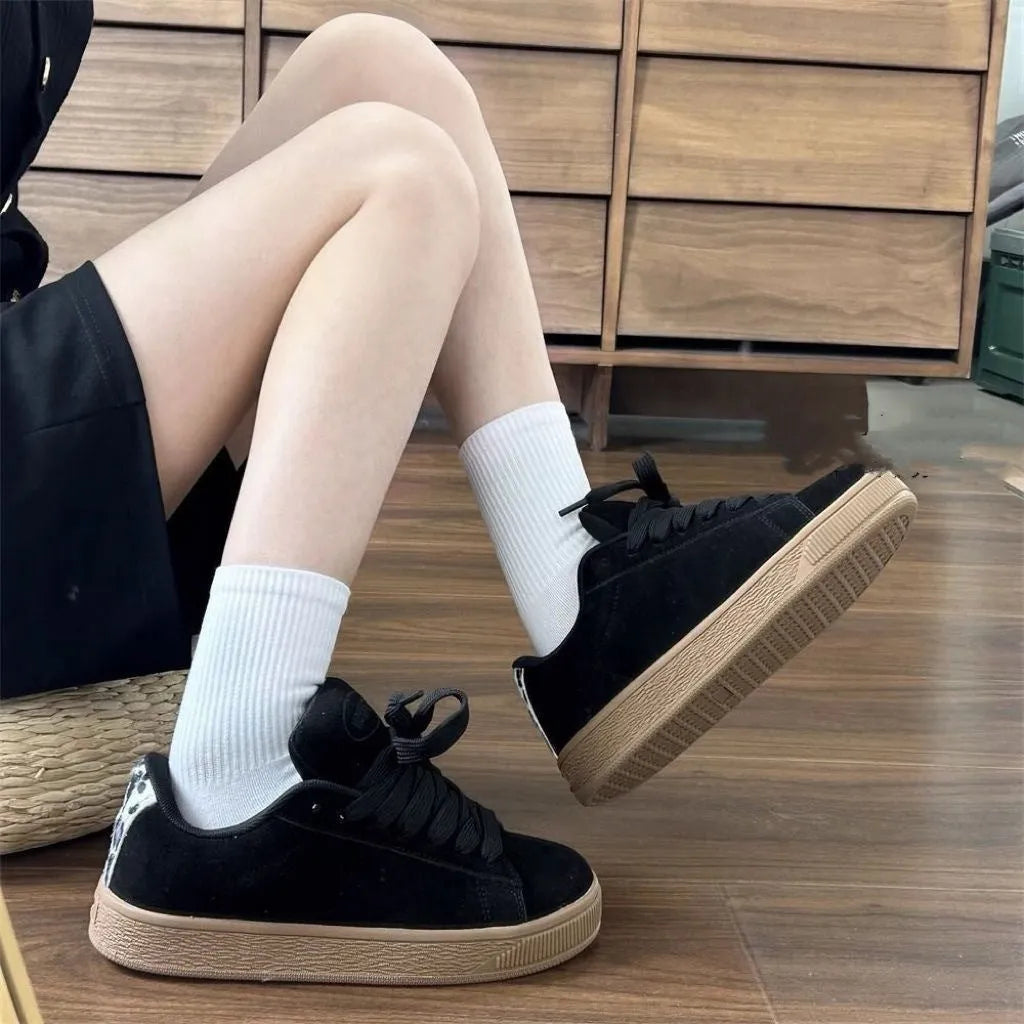 Retro black low-top sneakers on a waterproof platform sole with round toe and lace-up front.