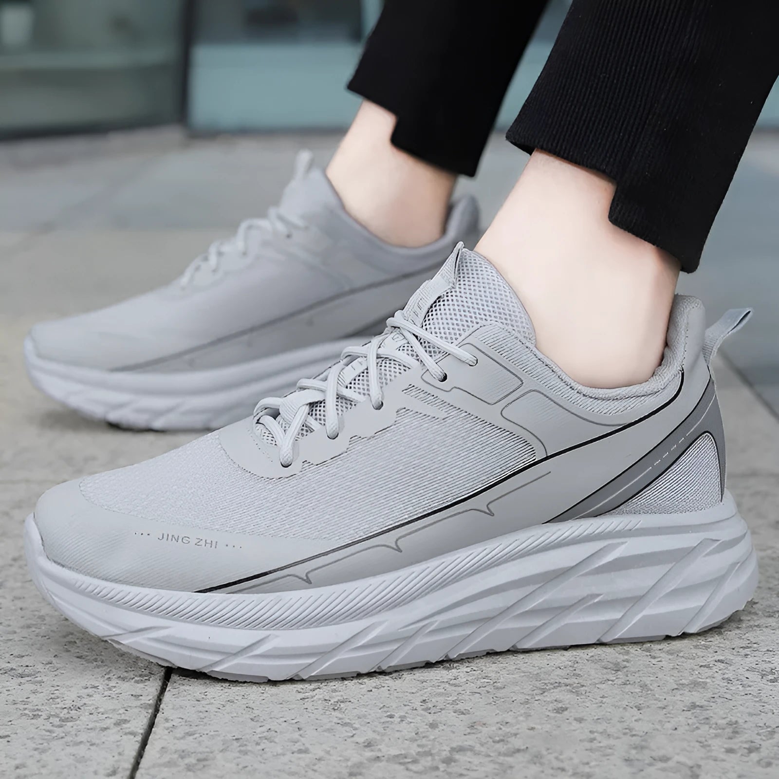 Men's black thick-soled anti-skid lace-up running sneakers with round toe and rubber sole on grey background