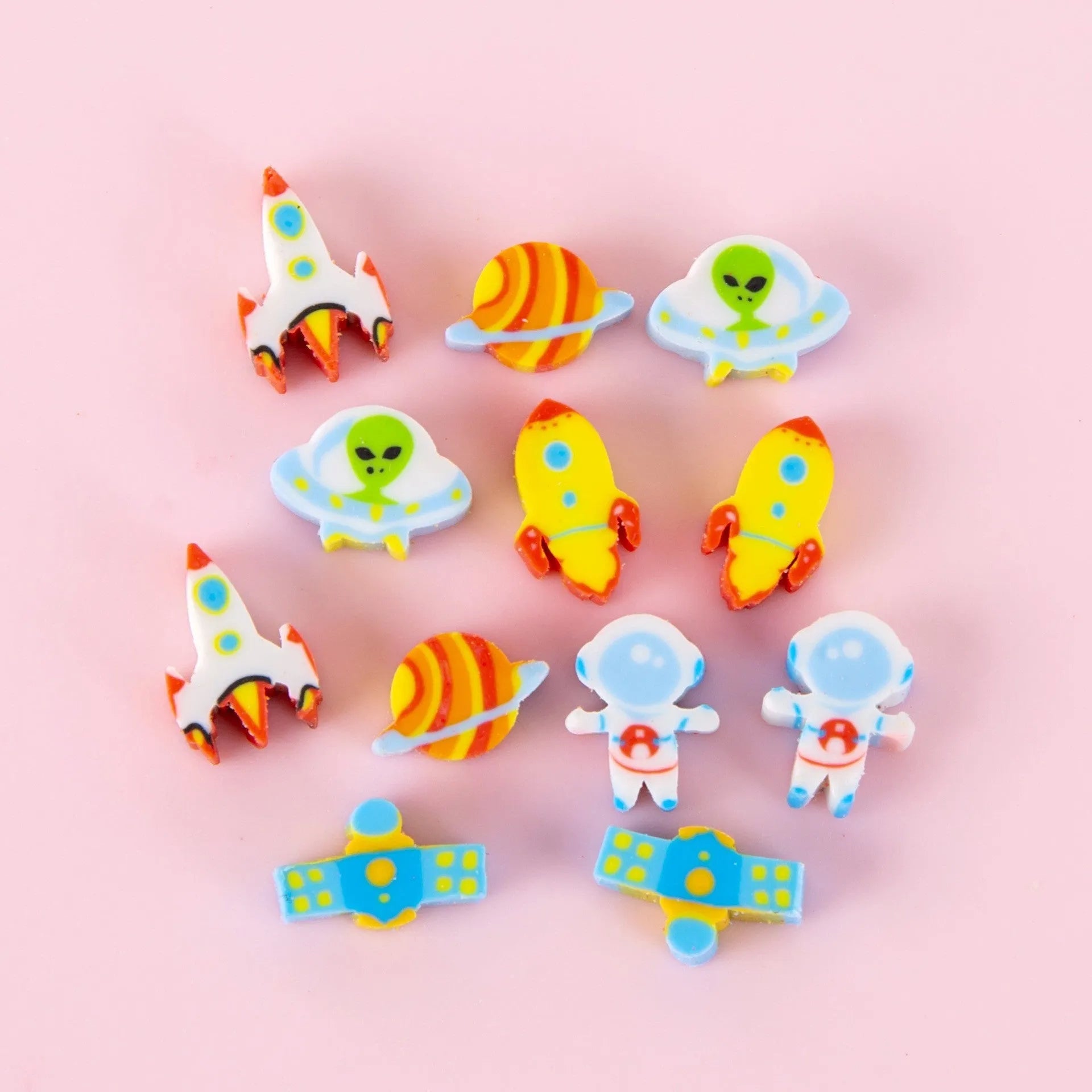 Sealed plastic bag containing 50 small cartoon-themed erasers in shapes like fruits, animals, and Christmas symbols.