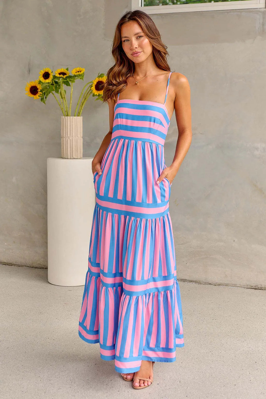 Long striped backless summer dress with square neckline and side pockets on a mannequin