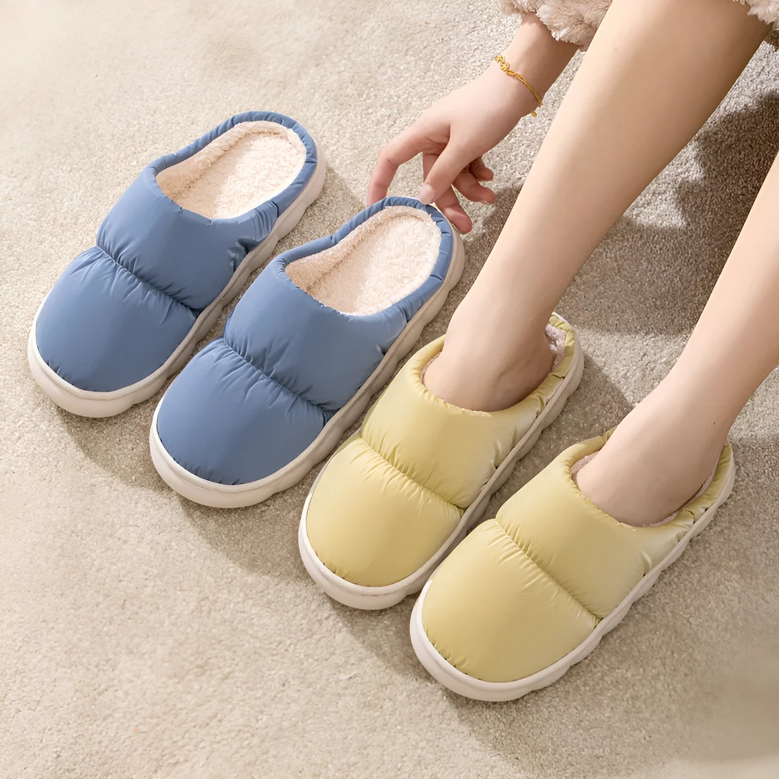 Blue down cotton winter slippers with a thick rubber sole and plush lining, shown on a wooden floor.