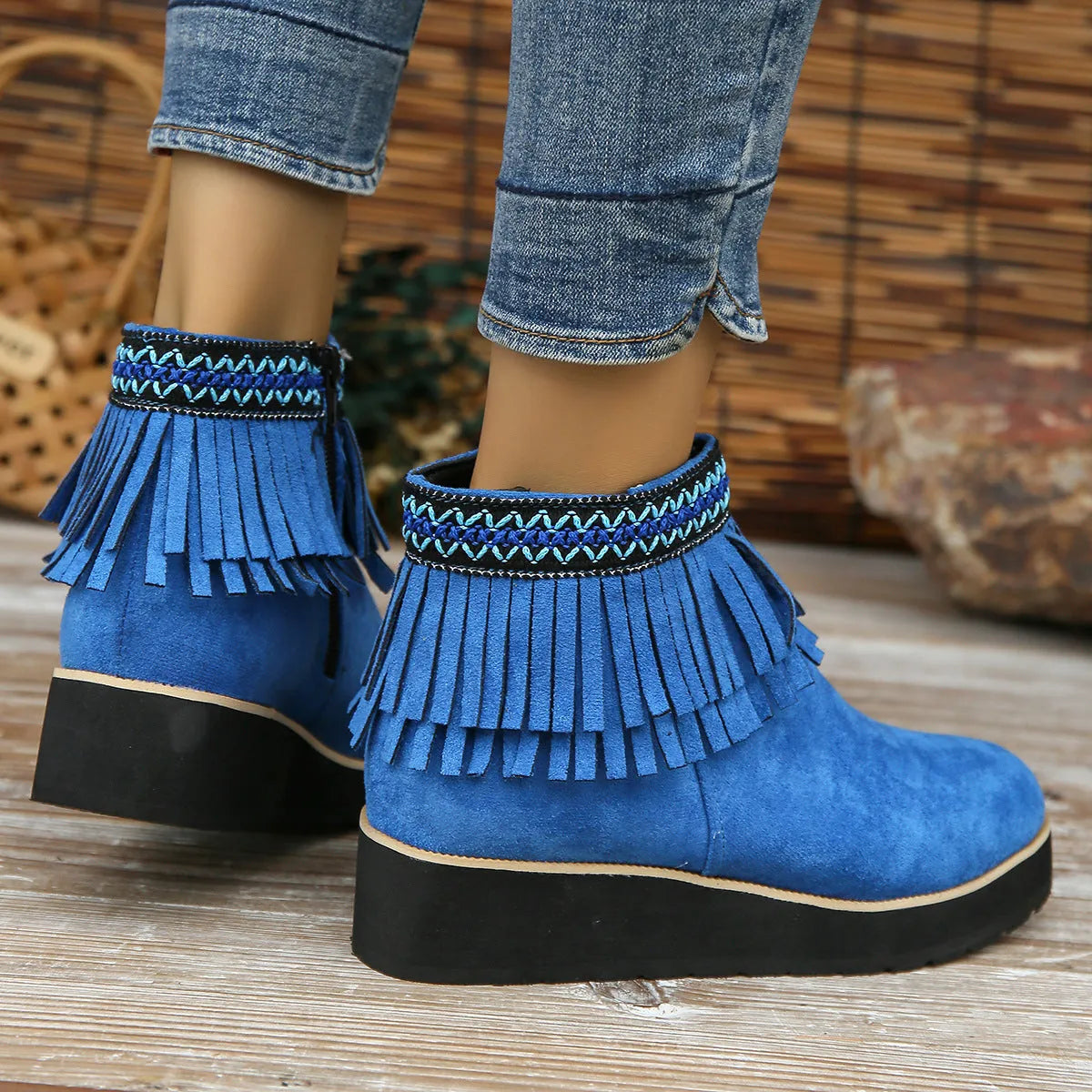 Women's suede wedge ankle boot with tassel detail, side zip, and a thick rubber sole.