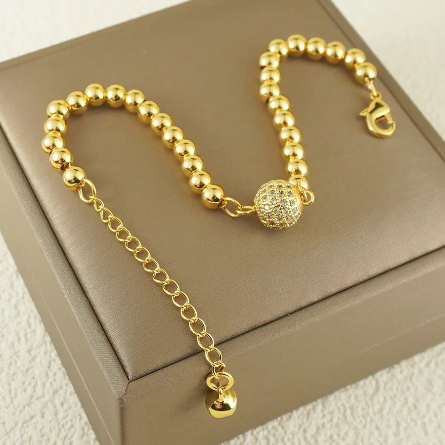 Close-up of a women's copper bracelet with a heart shape design and round zircon stone accents in an Arabic style.