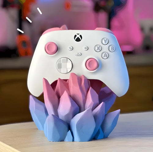 3D printing gamepad bracket in gradient colour, 20cm x 15cm x 10cm, on a desk beside a console