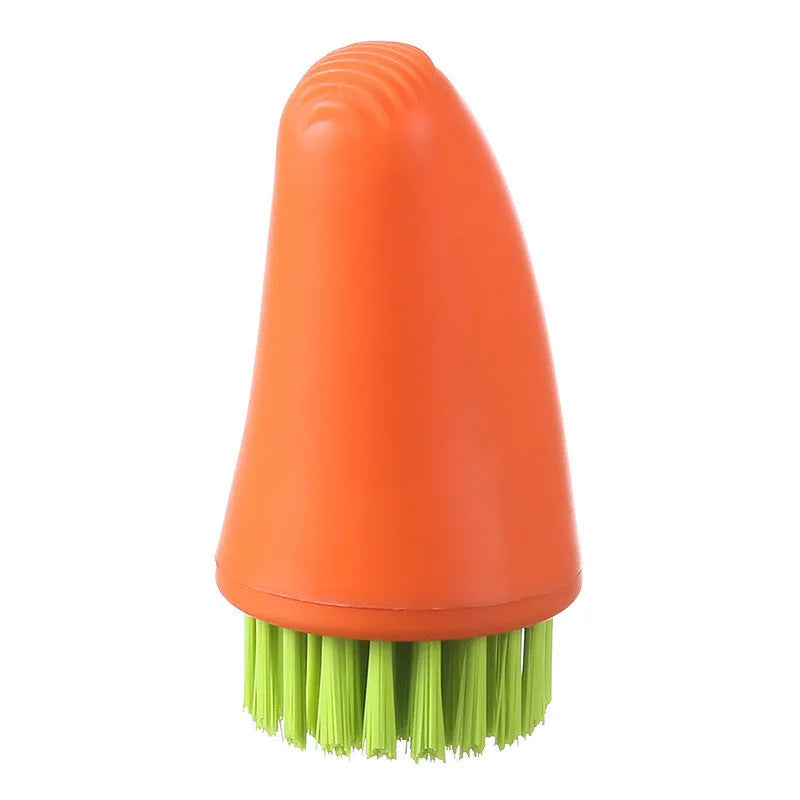 Orange and white carrot-shaped nylon kitchen cleaning brush on a plain background.