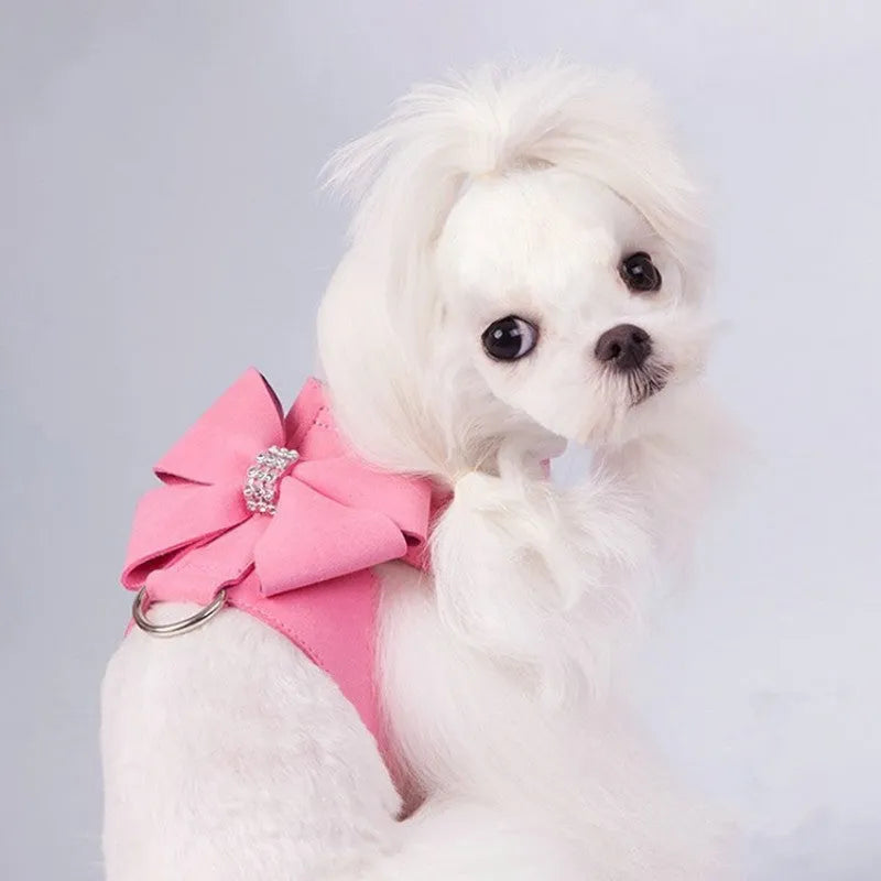A pink microfiber dog chest strap with a white bowknot, showing the adjustable size buckles.