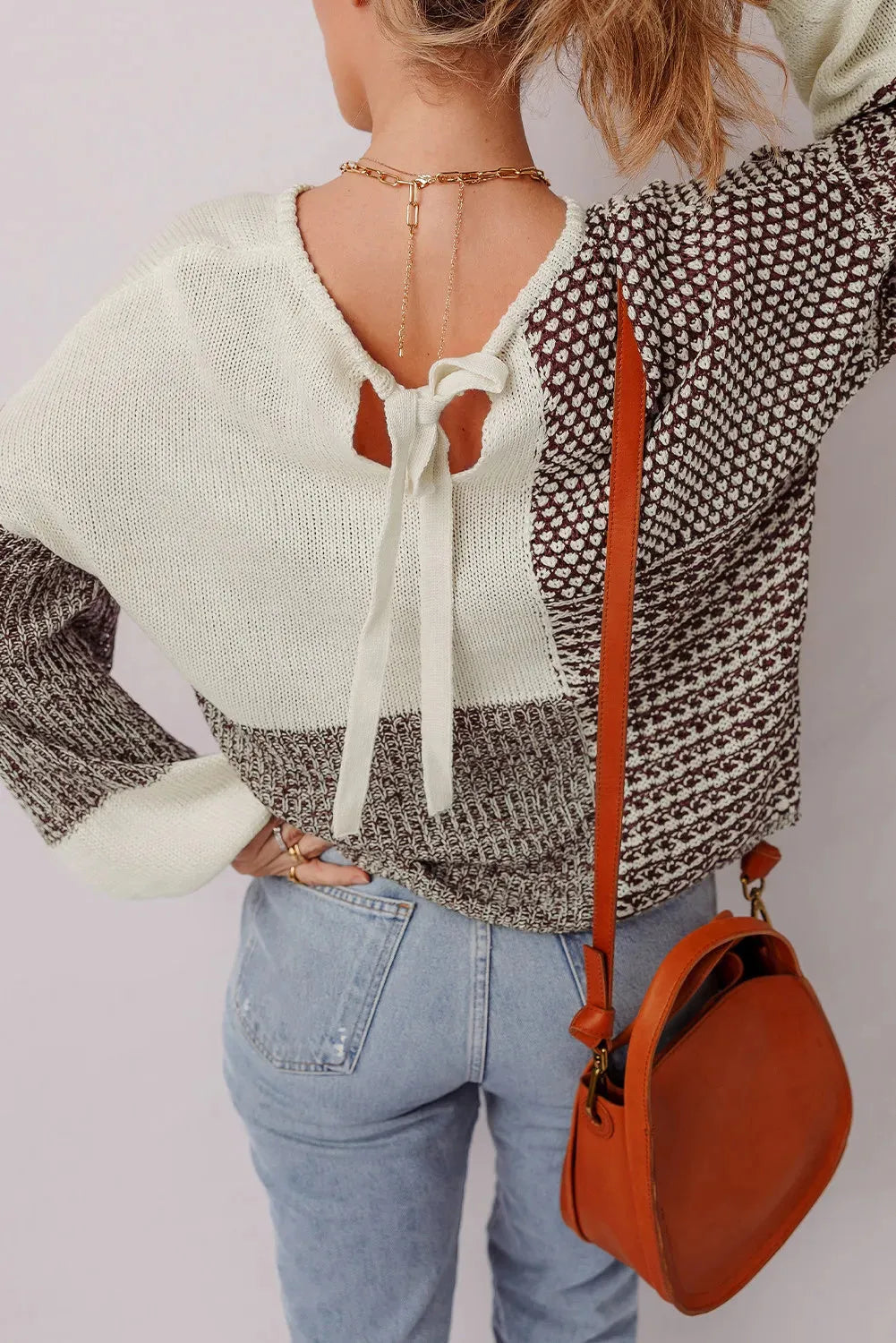 Dark khaki colour-block loose sweater with a back tie and drop shoulders on a hanger.