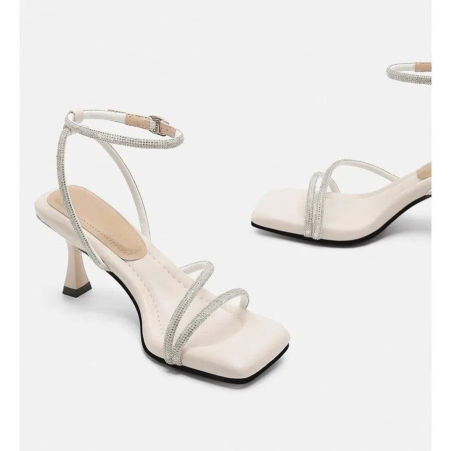 Women's silver high heel sandals with square toe, rhinestone detail, and an ankle-strap buckle.