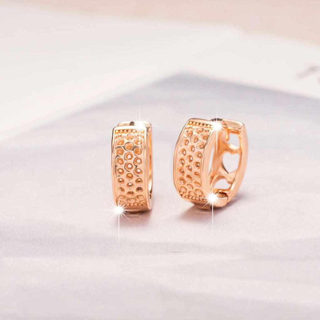 Rose gold women's earrings featuring a hollow heart shape inside a circular frame.