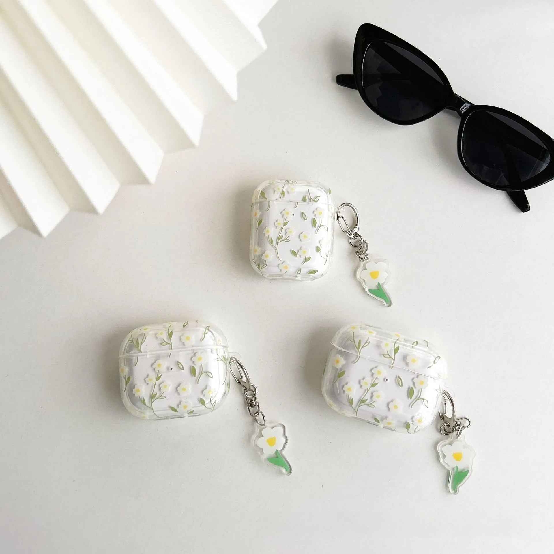 White floral pattern clear TPU protective case for Apple AirPods on a charging case.