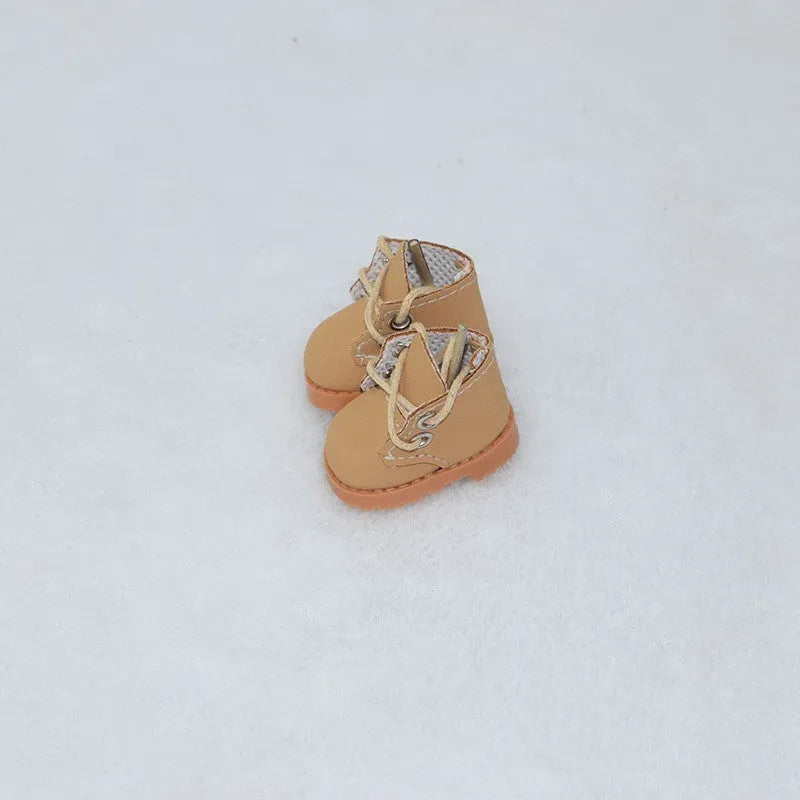 A pair of miniature PU replacement shoes for a 17cm fashion doll, shown in a selected style such as black boots.