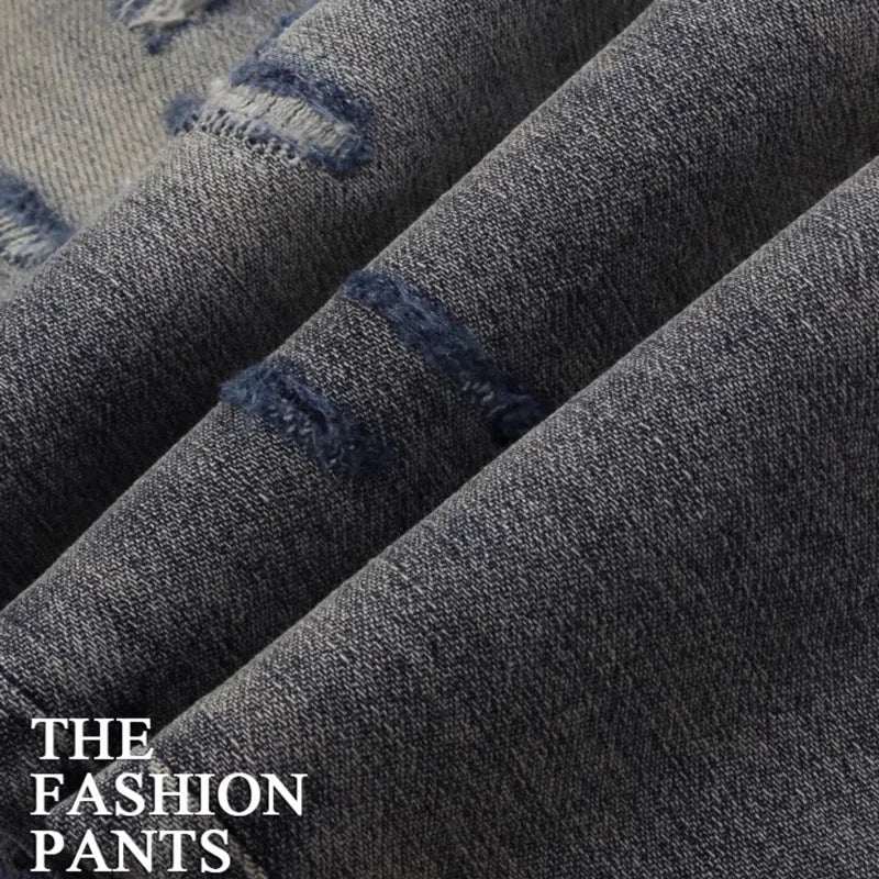Men's slim fit washed-out denim jeans with hole patches and embroidery on a mid waist.