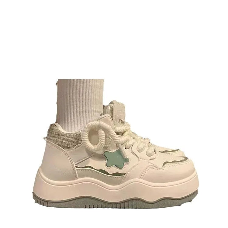 Women's green patent leather platform sneakers with round toe and lace-up closure on rubber sole