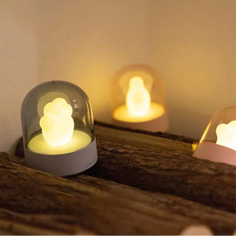 Grey and pink cat paw shaped USB rechargeable night light with rotating dynamic lighting