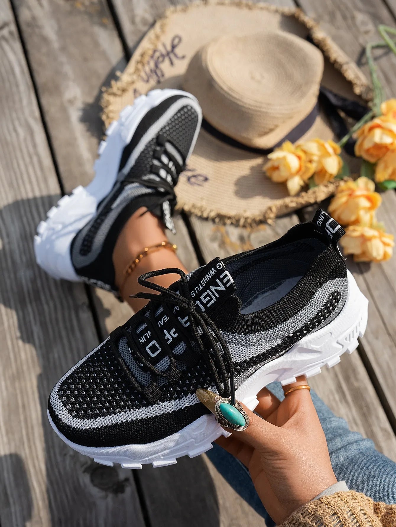 Women's Flyknit mesh lace-up sneakers in grey and white with a low rubber sole.