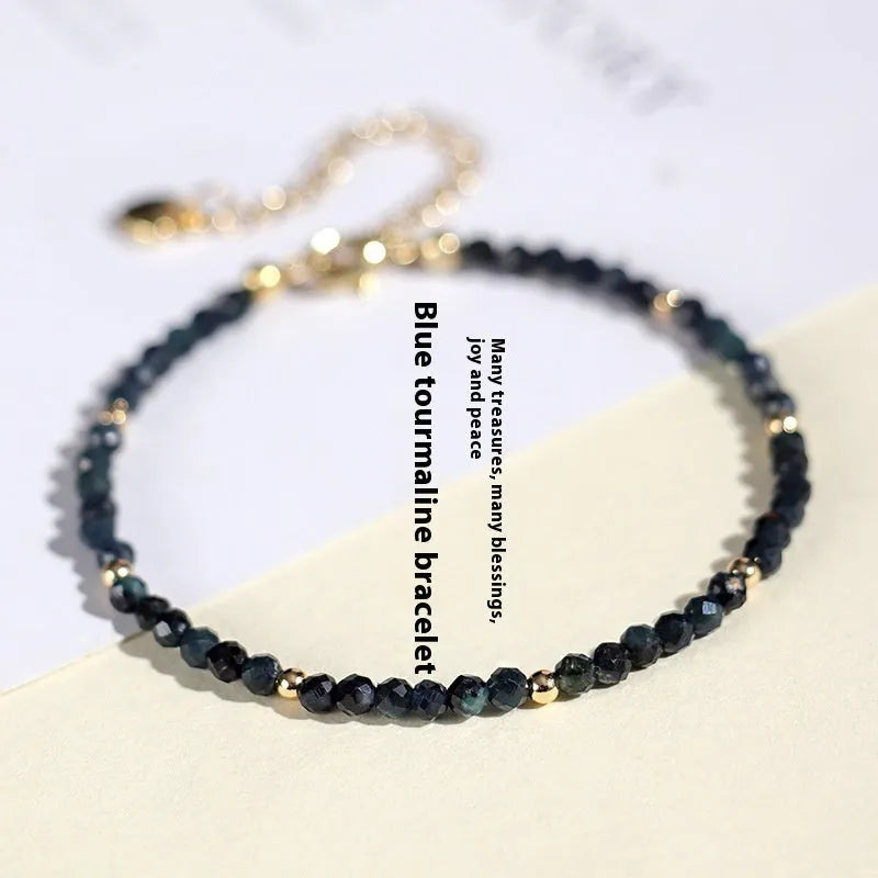 Blue tourmaline gemstone bracelet with 3mm cut beads on a white background.