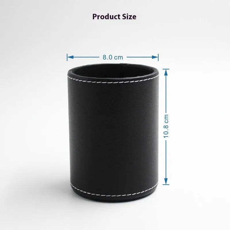A small, round black leather pen holder standing on a wooden desk.