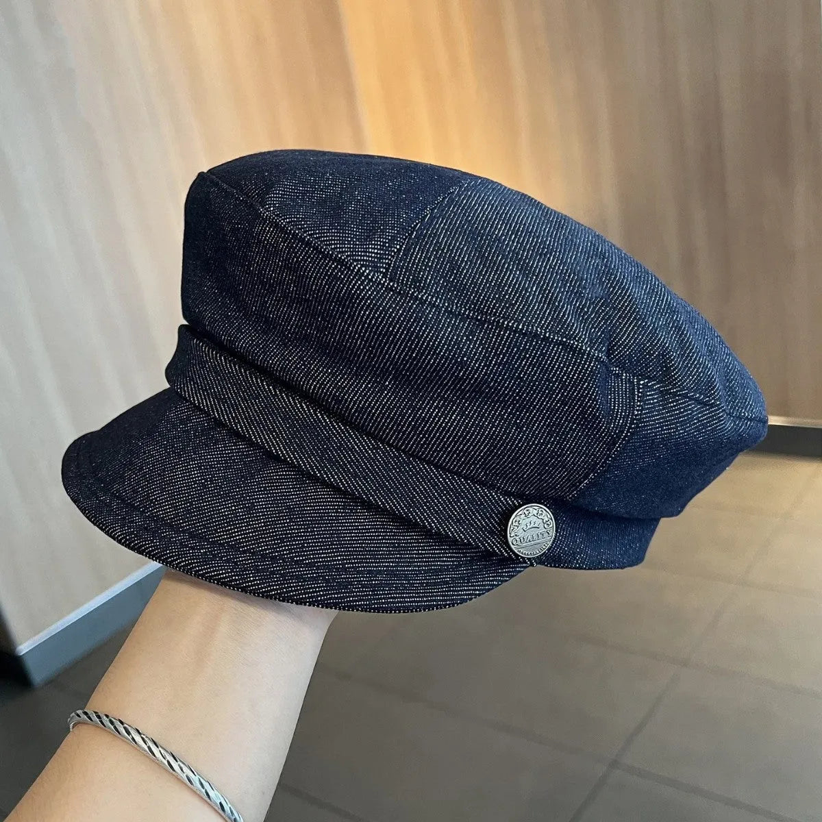 Dark blue denim newsboy hat with octagonal retro design and adjustable sizing