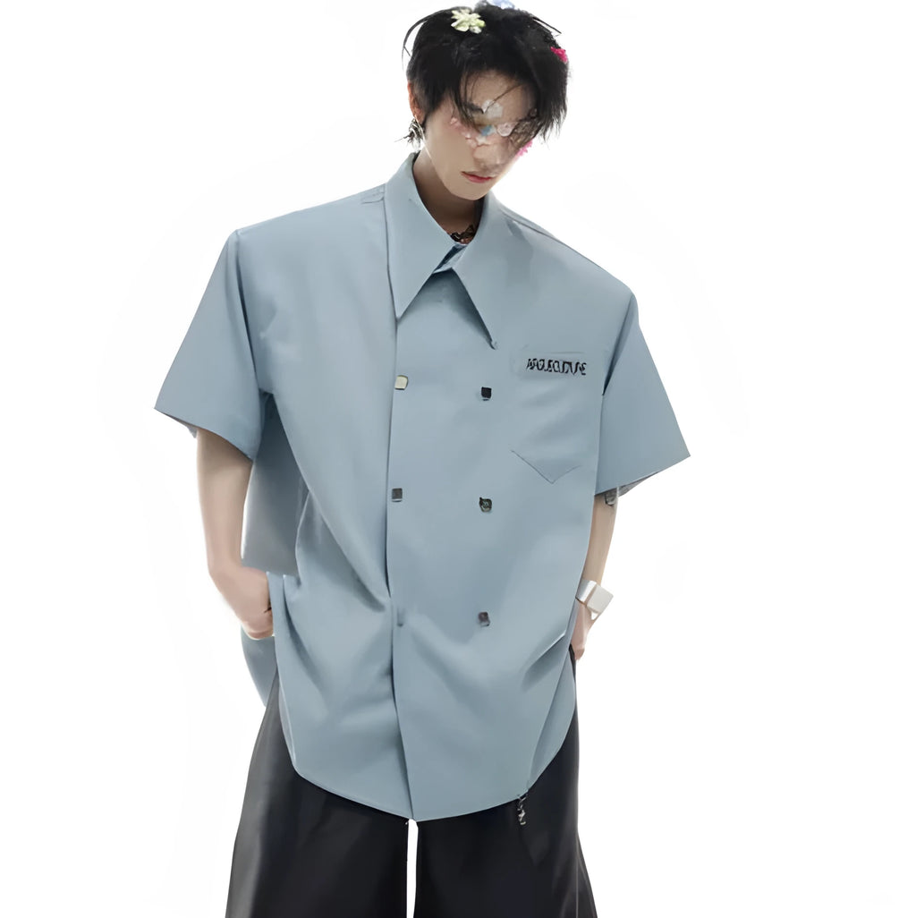 A man's loose-fitting short-sleeved casual shirt in a light colour with a lapel collar and decorative button detail.