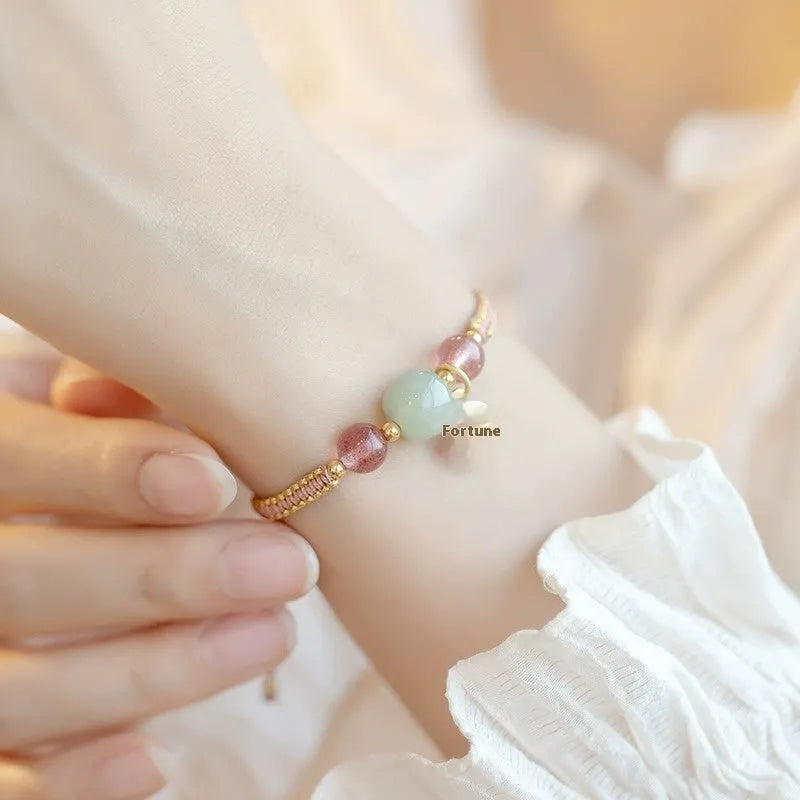 Adjustable red rope bracelet with a choice of Strawberry Quartz or Hetian Jade bead, showing the national style design.