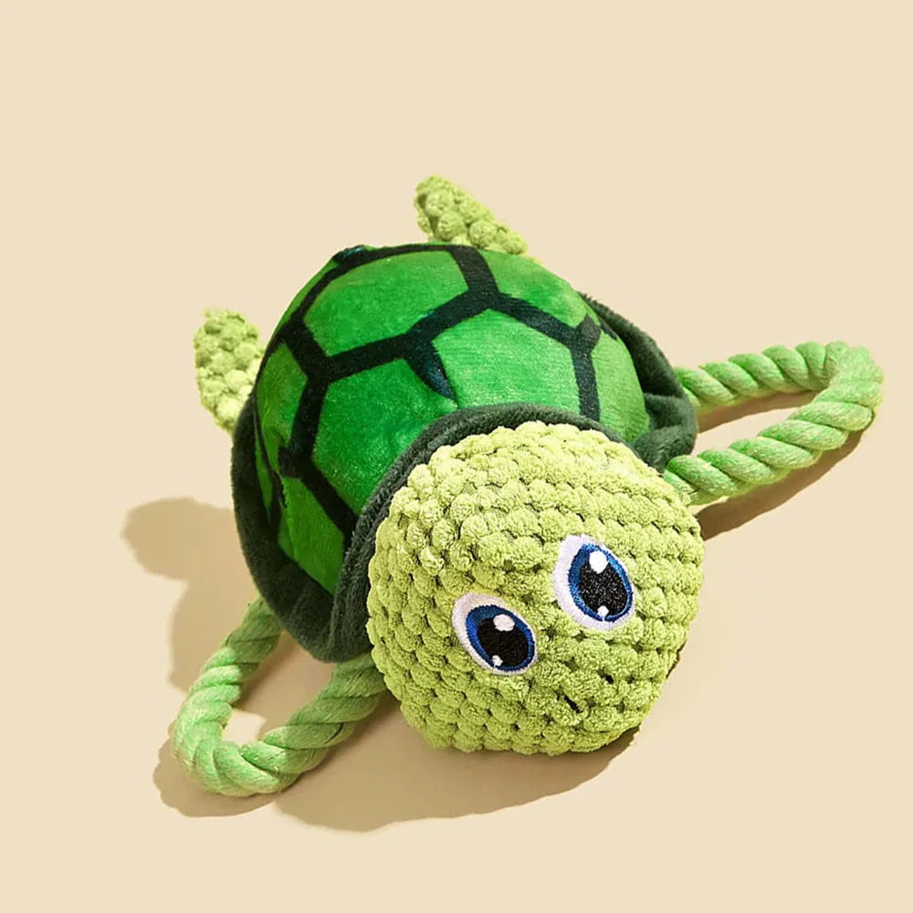 Turtle-shaped plush dog toy with knotted interior and squeaker in grey, green and orange colours