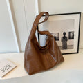 Soft PU leather large capacity shoulder bag in black with a sandwich pocket and contrasting stitching.