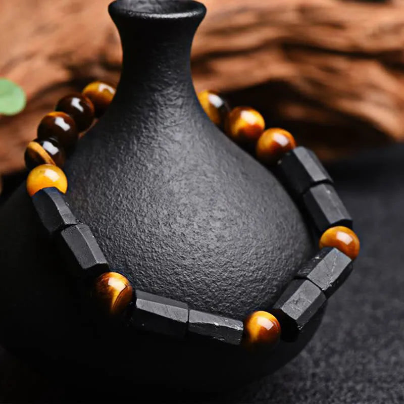 Natural obsidian single ring bracelet with constellation modelling on a wrist.