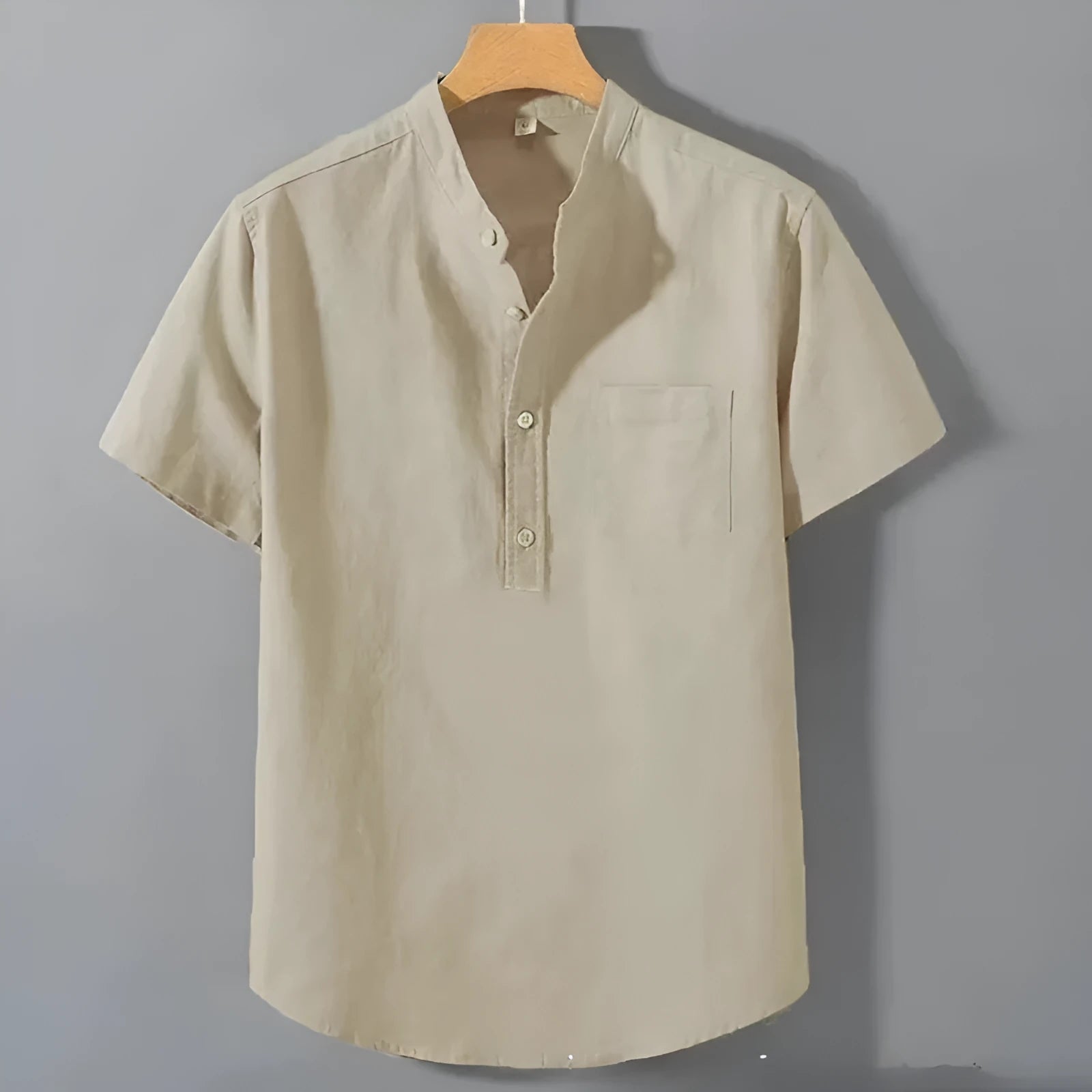 Man wearing a beige slub linen casual shirt with a stand collar and short sleeves.