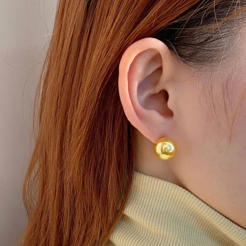 Large pearl stud earrings with a geometric star detail, shown in silver.