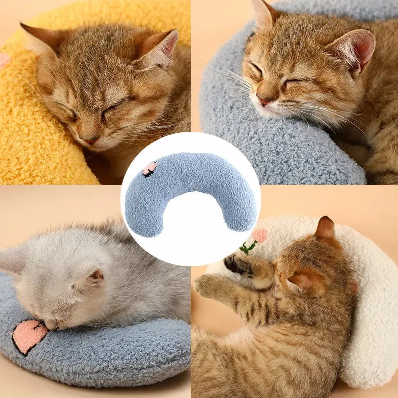 White U-shaped plush pet pillow for a small cat or dog on a grey background.