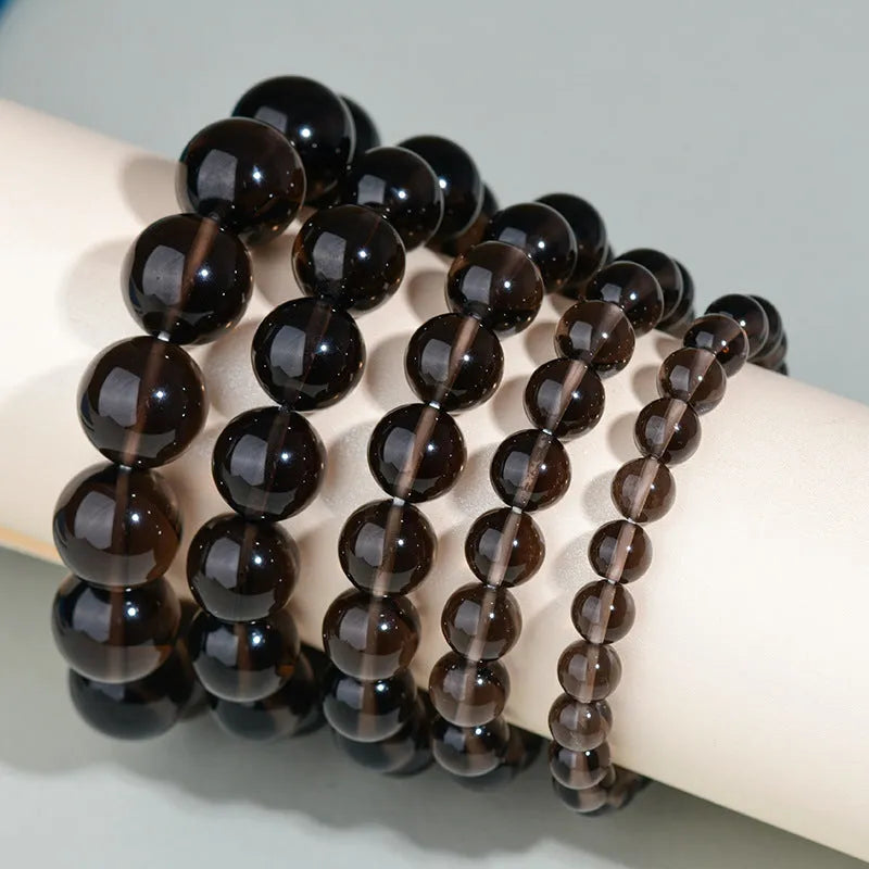 Hand-woven round obsidian bead bracelet on a wrist, showing ethnic style and multiple colour options.