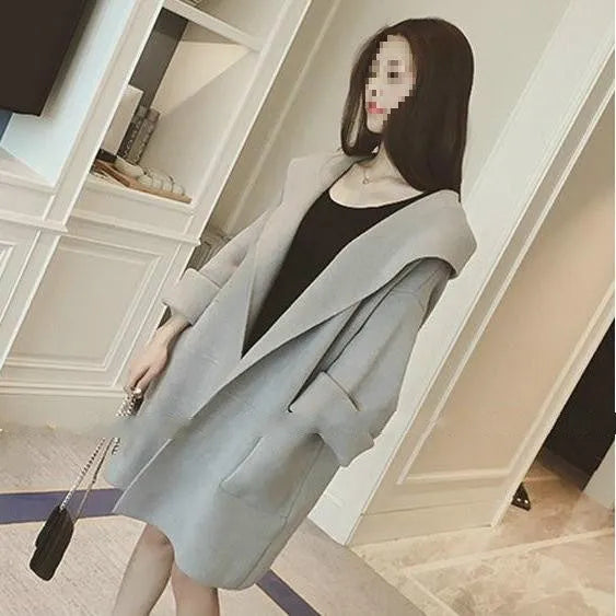 Plus size woman wearing a grey loose-fit cotton coat with lace detailing and long sleeves.