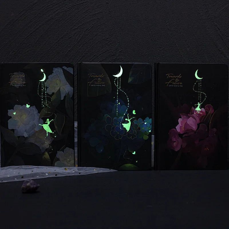 A5 notebook with luminous reflective cover open to show pages with colourful illustrated backgrounds.