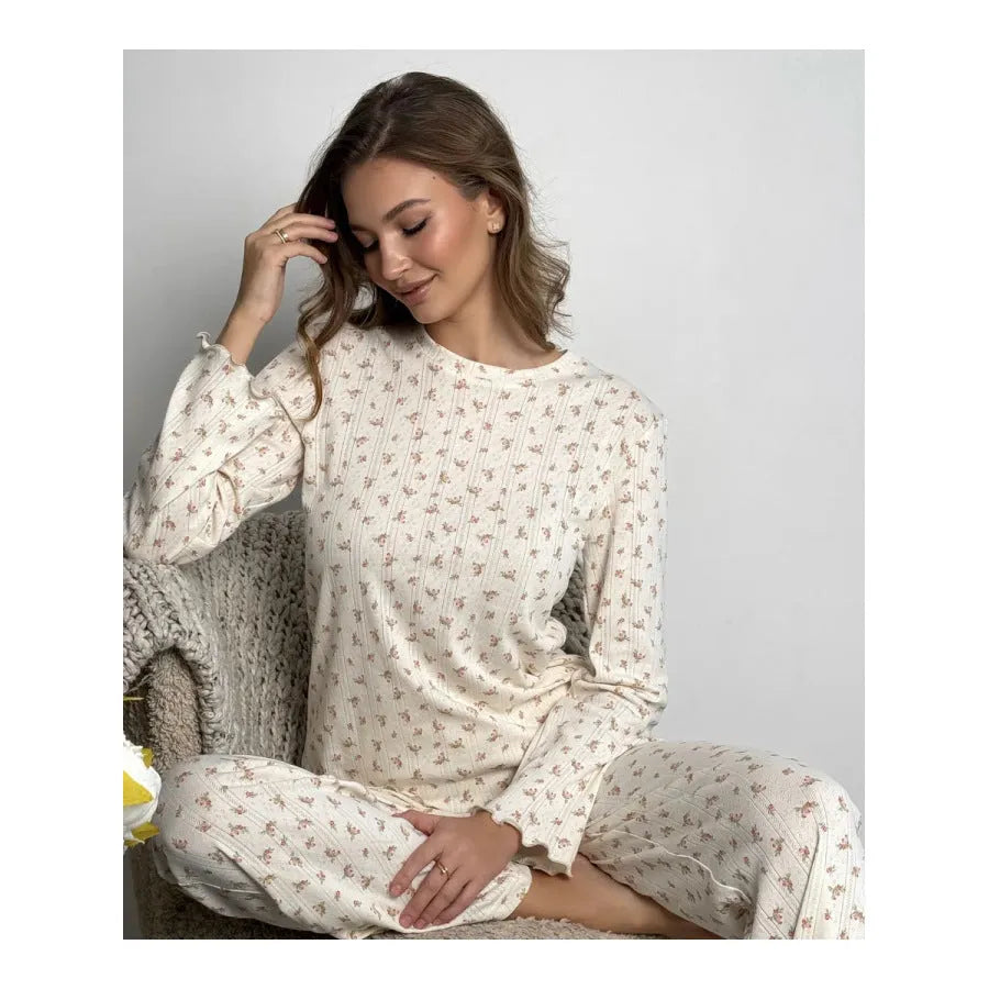 White women's floral print bell sleeve top and wide leg pants suit laid flat.
