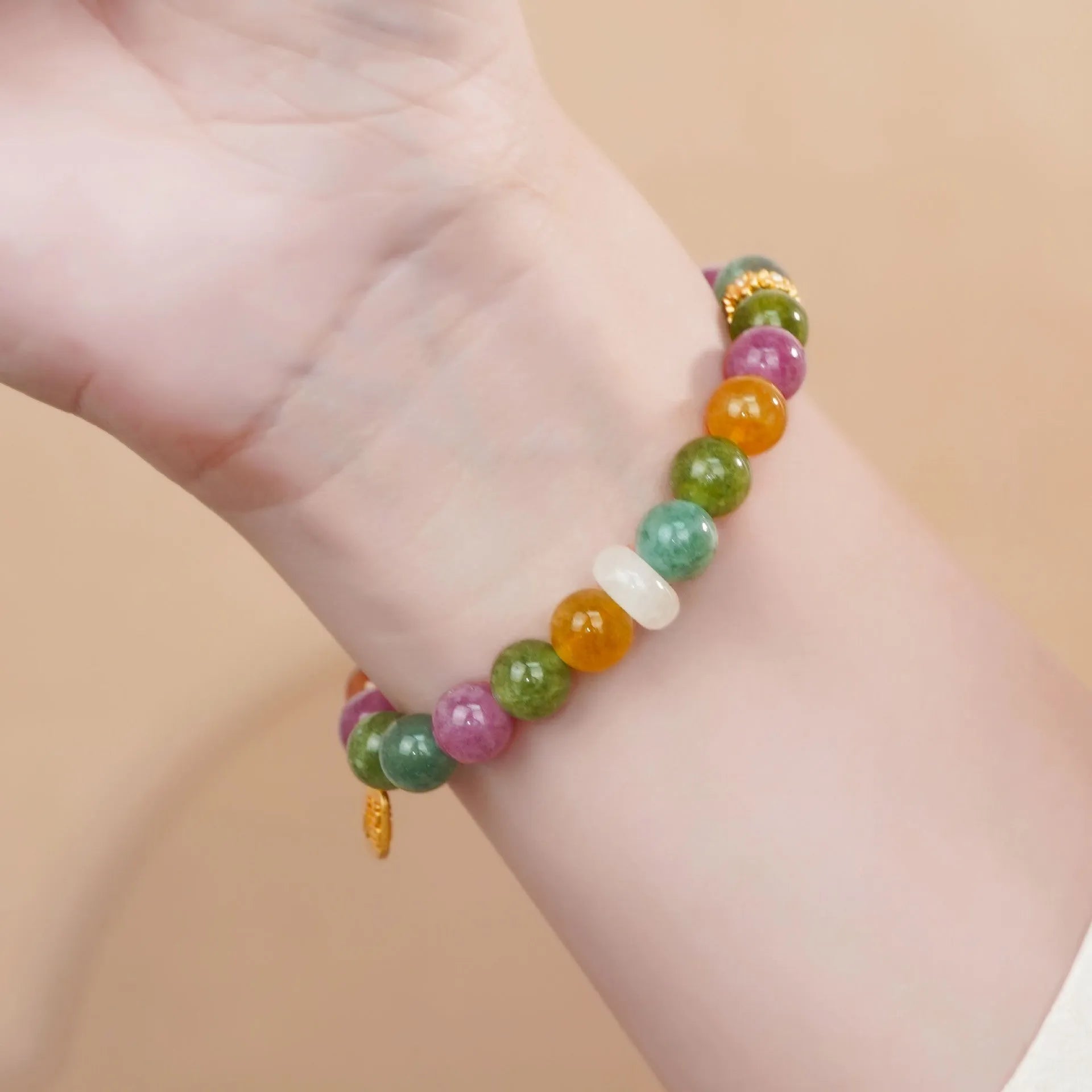 Women's rainbow tourmaline half bracelet with electroplated finish showing natural stone colour variations