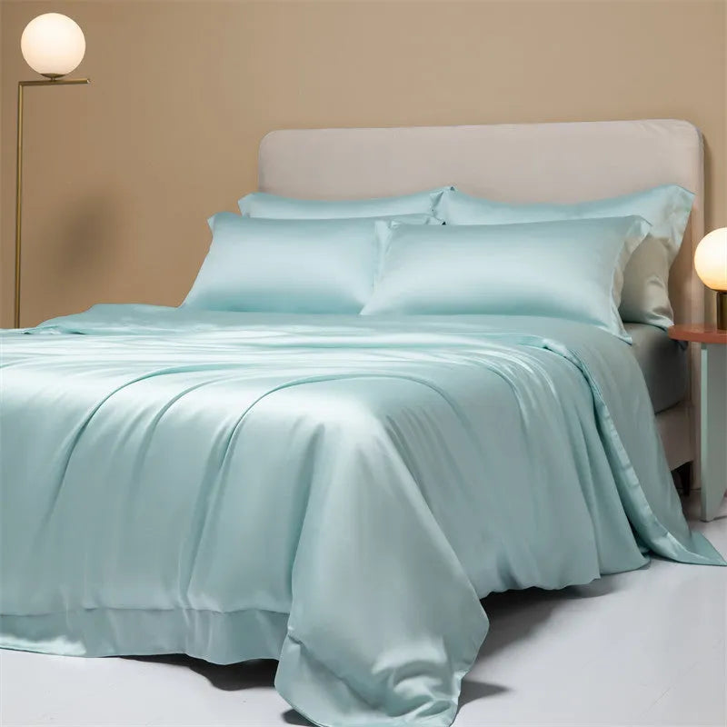 Luxury Lenzing Tencel bedding set in Aurora Blue on a bed, showing quilt cover, sheet, and two pillowcases.
