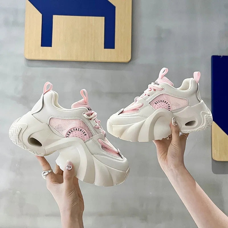 Women's pink casual sneakers with thick sole, cross straps, and mesh lining.