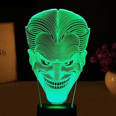 USB-powered 3D acrylic LED lamp displaying multiple colours on a desk with remote control.