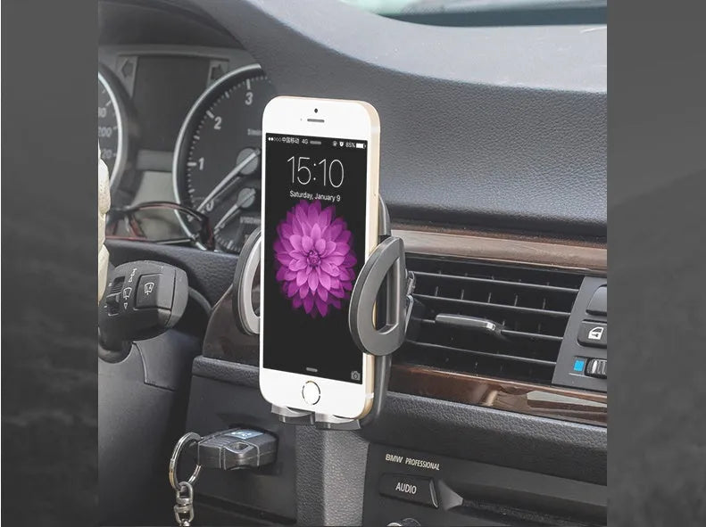 Black plastic car air vent phone holder attached to vehicle air conditioning outlet with mobile phone secured