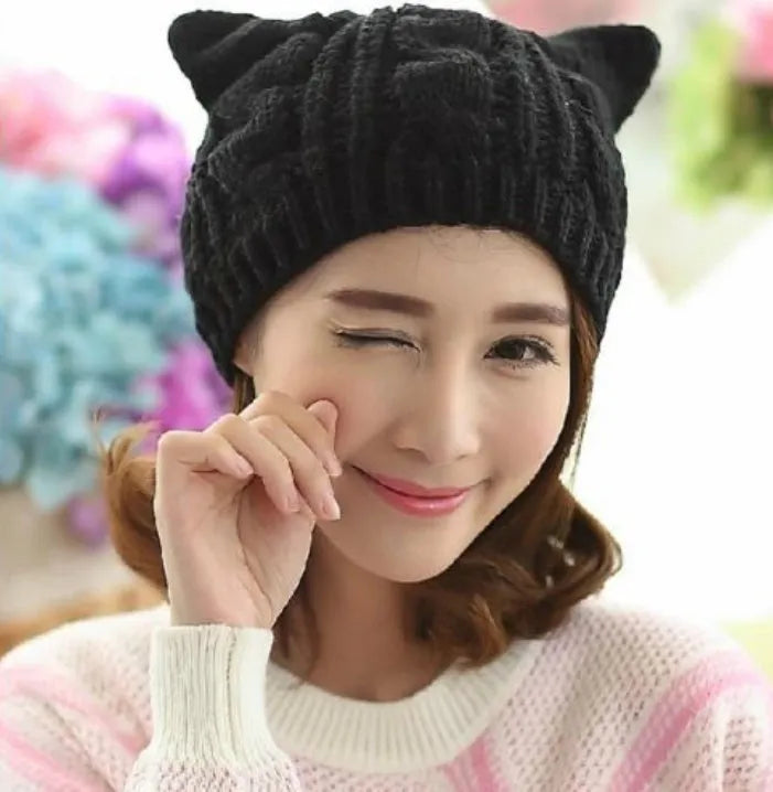 Hand knitted red wool beanie with 3D cat ears on a white background