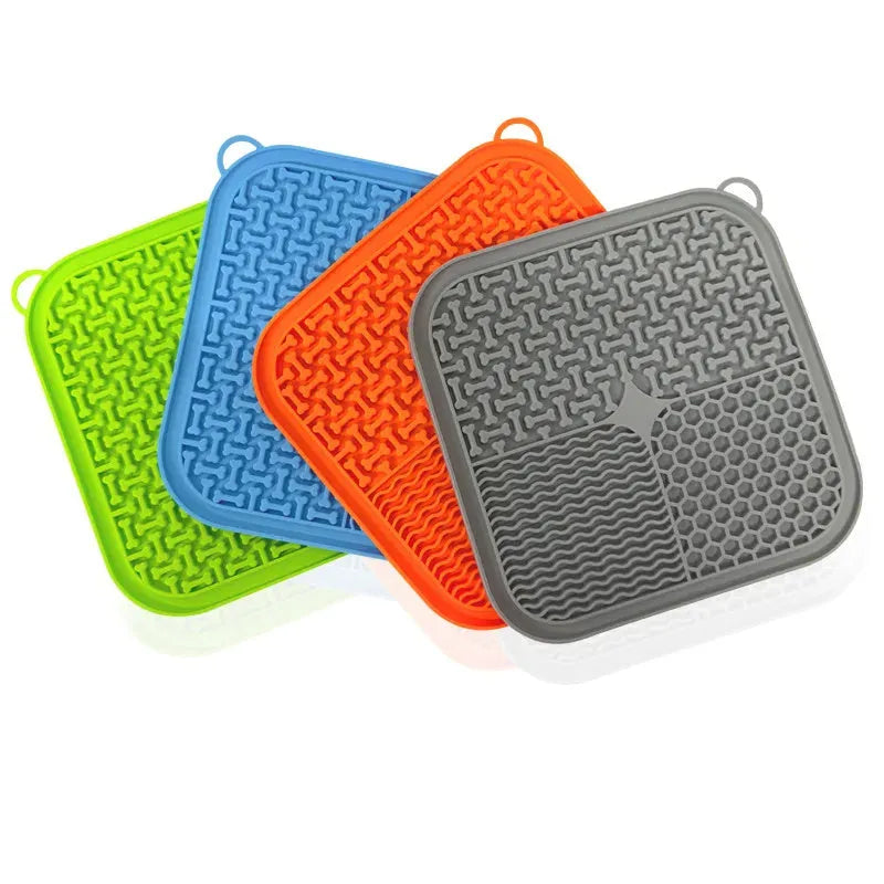 Blue silicone dog licking mat with textured surface and suction cups on a clean floor.