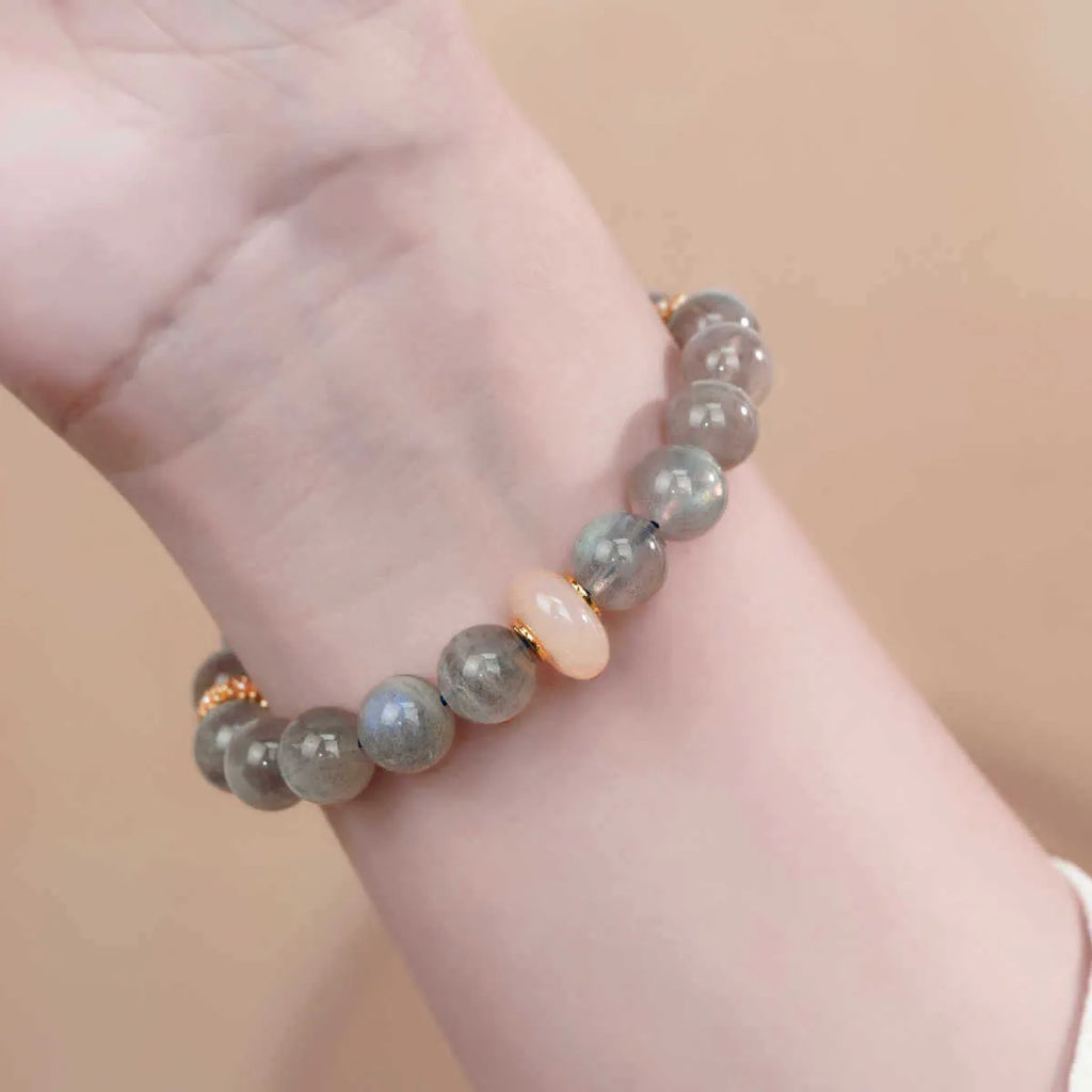 Grey moonstone women's bracelet with 8mm round beads on a wrist.
