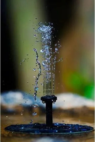 Black solar-powered fountain pump with multiple nozzles on a small pond or bird bath.