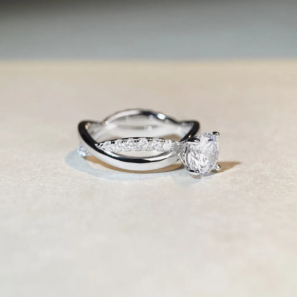 Geometric cross design silver ring with a 1 carat moissanite stone and twisted arm winding.