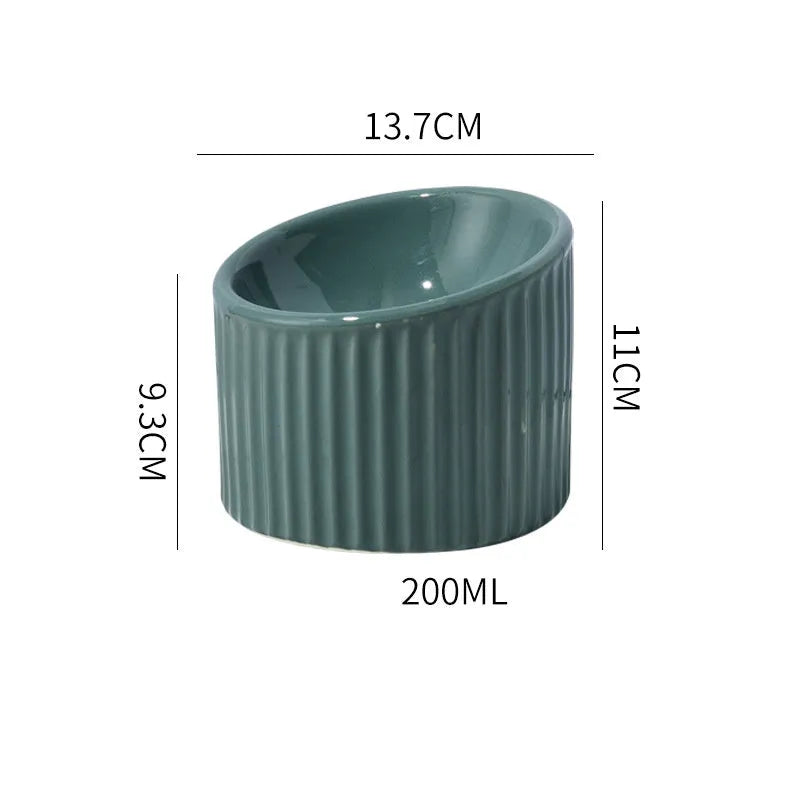 Elevated ceramic cat bowl in light green, showing tilted design and round whisker-friendly shape